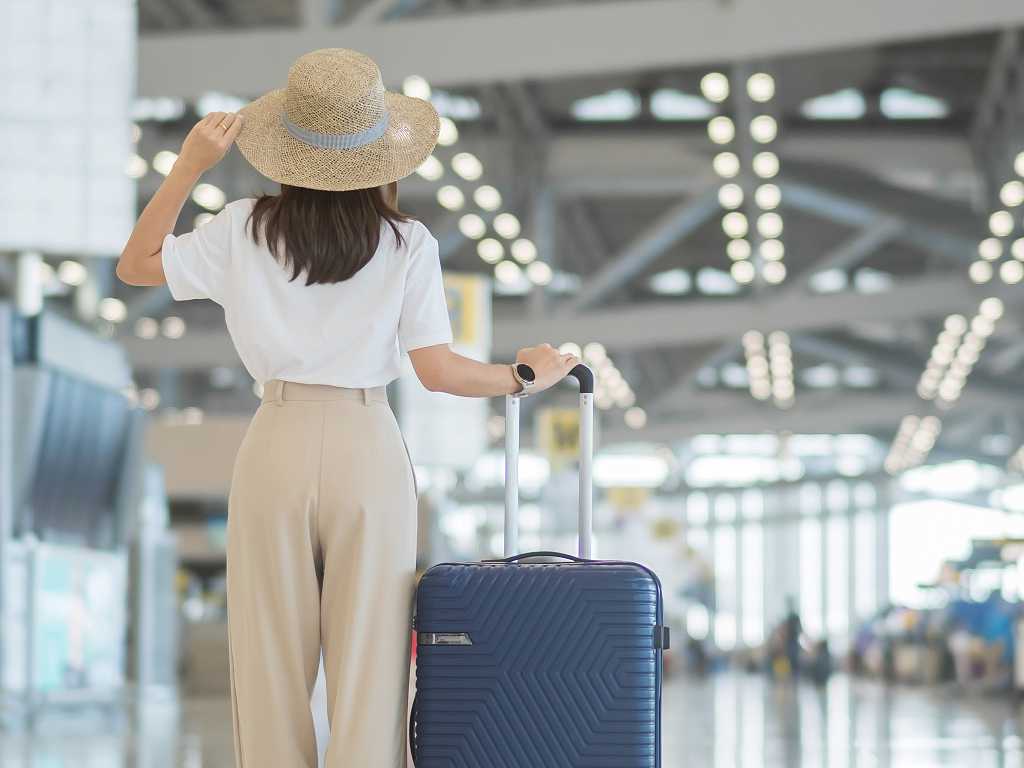 Eine Frau mit Koffer am Flughafen